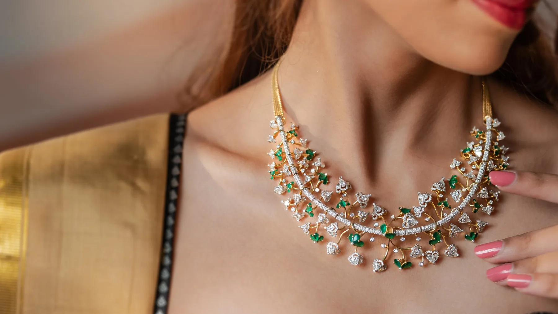 Diamond and emerald necklace in gold, worn with a gold Kanchivaram silk saree